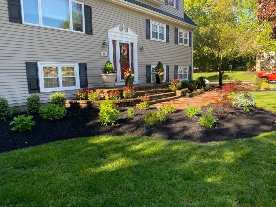 Front foundation beds mulched and replanted at a colonial home.