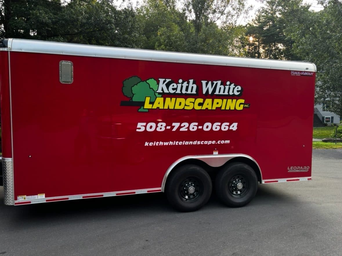 The Keith White Landscaping enclosed trailer with company logo and phone number.